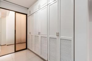 a walk in closet with white cabinets and a mirror at Amplios Apartamentos San Fernando Cerca a Centros Médicos in Cali