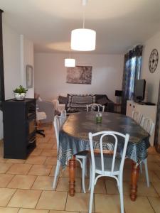 a dining room and living room with a table and chairs at Gite de la plage proche de la Saône in Autet