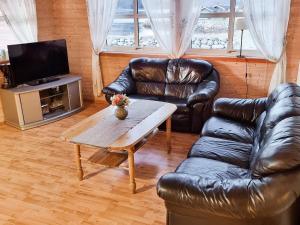 a living room with a leather couch and a table at 4 person holiday home in Selje in Selje