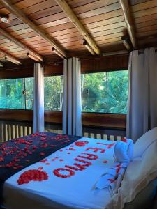 a bedroom with a bed with red roses on it at Pouso bom retiro in Paraty