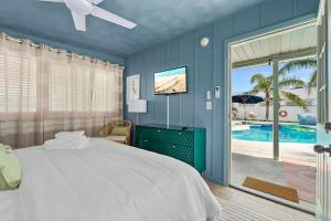 a blue bedroom with a bed and a pool at Walk to Beach, Heated Pool, Dog-Friendly, Firepit in Daytona Beach
