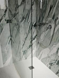 una doccia con porta in vetro in bagno di Exclusive Place Monolocale in Villa Ardea ad Ardea