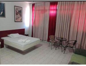 Hotel Canal Hum Pistão في برازيليا: غرفة نوم بسرير وطاولة وكراسي