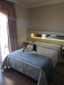 um quarto de hotel com uma cama com uma bandeja em Pousada Serra Valle em Gramado