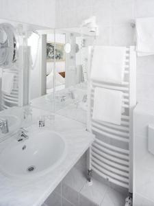 een witte badkamer met een wastafel en een spiegel bij Haus Von Der Heyde in Iserlohn