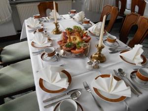 Haus Von Der Heyde في إزرلون: طاولة عليها قماش الطاولة البيضاء مع الطعام