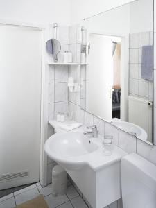 a white bathroom with a sink and a mirror at Haus Von Der Heyde in Iserlohn