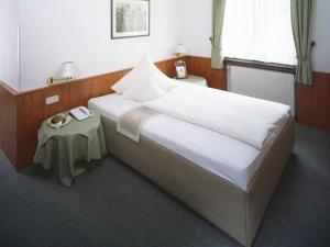 a bedroom with a large bed and a table at Haus Von Der Heyde in Iserlohn