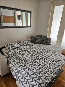Belville City apartment في بلغراد: غرفة نوم بسرير كبير ومرآة