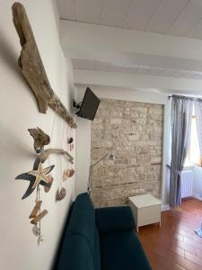 sala de estar con sofá azul y pared de piedra en La Cialdina - La CONCHIGLIA Sirolo Apartment, en Sirolo