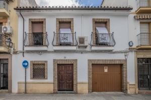 een wit gebouw met balkons en deuren erop bij Casa con patio María Auxiliadora in Córdoba
