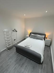 a bedroom with a large bed with white sheets at Luxury 2 Bed Apartment, Sleeps 6 with Sofa bed, Close to Sale Tram Station in Sale