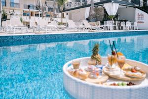 a tray of food sitting next to a swimming pool at Padam Hotel & SPA in Ulcinj