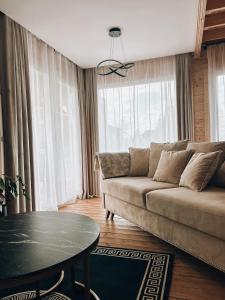 uma sala de estar com um sofá e uma mesa em Parkowy Kudowa em Kudowa-Zdrój