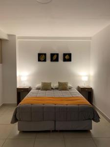 Un dormitorio con una cama grande con dos mesitas de noche. en Bouchard-Ushuaia Flat, en Ushuaia
