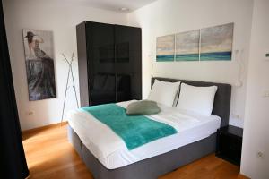 Un dormitorio con una cama con una manta verde. en Argo Apartments en Liubliana
