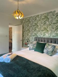 伯青頓的住宿－North Lodge at Quex Park，卧室配有带绿色枕头的大型白色床