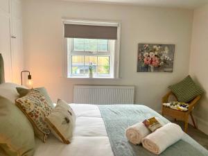a bedroom with a white bed with towels on it at North Lodge at Quex Park in Birchington
