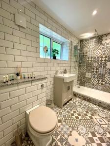 伯青頓的住宿－North Lodge at Quex Park，浴室配有卫生间、盥洗盆和淋浴。