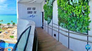 a building with a green wall with a view of the ocean at Vacanze - Sky Concept Flats in Maceió +36 photos