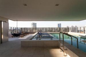 a large building with a swimming pool on a roof at Nik Perdizes - Studios por temporada in Sao Paulo
