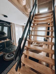 uma escada de madeira num quarto com pisos de madeira em Parkowy Kudowa em Kudowa-Zdrój