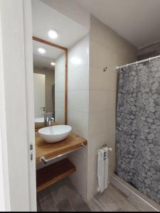 a bathroom with a sink and a glass shower at Village de Mar in Monte Hermoso