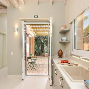 a kitchen with a door leading to a patio at The OliveStone Village - Yoga Retreat Paradise in Ágios Márkos