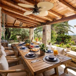 una mesa de madera con platos de comida en el patio en The OliveStone Village - Yoga Retreat Paradise en Ágios Márkos