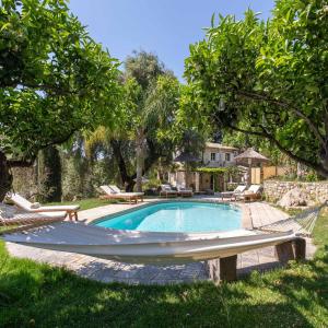 a swimming pool with a hammock in a yard at Corfu OliveStone Village with Swimming pool in Ágios Márkos