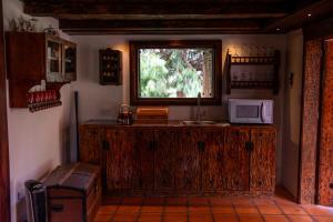 a kitchen with a counter with a microwave and a window at Hacienda Hostería Dos Chorreras in Cuenca