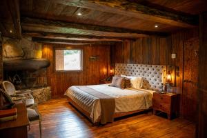 1 dormitorio con 1 cama en una habitación con paredes de madera en Hacienda Hostería Dos Chorreras, en Cuenca