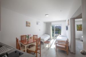 a kitchen with a table and a room with a bed at Pavlinia Hotel & Apartments in Ayia Napa