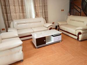 uma sala de estar com mobiliário branco e uma televisão em Kigali Nice Apartment em Kigali