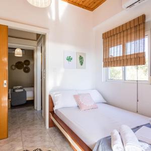 1 dormitorio con cama y ventana en Maisonette with Palms, en Stoupa