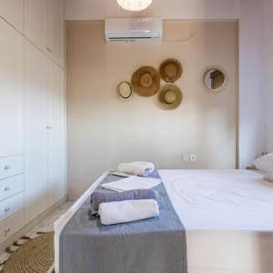 1 dormitorio con 1 cama con toallas en Maisonette with Palms, en Stoupa