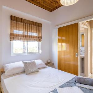Un dormitorio con una gran cama blanca y una ventana en Maisonette with Palms, en Stoupa