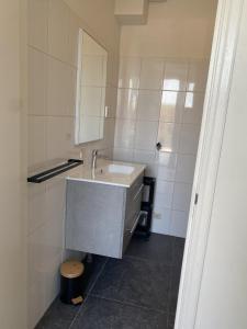 a bathroom with a sink and a mirror at Beach Dream 3C in Petten +21 photos