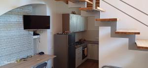 a kitchen with a refrigerator and a tv on the wall at L'antica Torre a Mare in Lascari