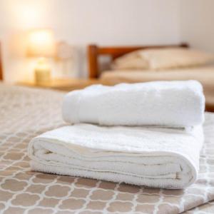 three towels are stacked on top of a bed at Seaside Retreat for Families and Pets in Messini +20 photos
