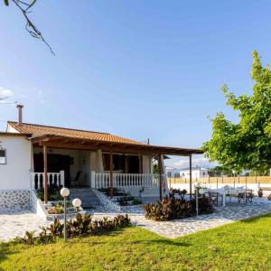 Casa blanca con porche y patio en Seaside Retreat for Families and Pets, en Messini