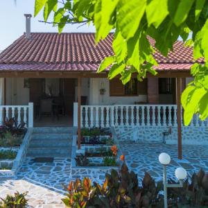 una casa con una cerca blanca y algunas plantas en Seaside Retreat for Families and Pets, en Messini