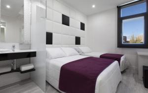 biała sypialnia z łóżkiem i umywalką w obiekcie Hoteles Urbanos N Avenida de España w mieście Fuenlabrada