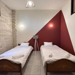 two beds in a room with red and white walls at Wave Side Old Souk Batroun Guest House in Batroûn