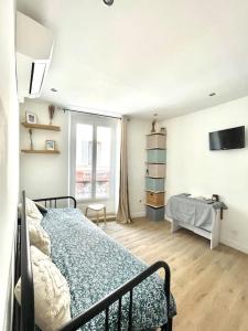 a bedroom with a bed and a television in it at Le Nid du Miroir in Martigues