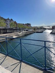 a river with a blue railing on the side of it at Le Nid du Miroir in Martigues