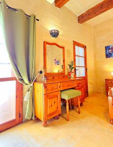 um quarto com uma secretária com um espelho e uma cadeira em Ta Katrin 3 Bedroom Farm House em Xaghra