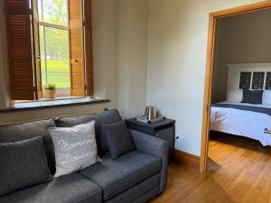 een woonkamer met een bank en een bed bij Auberge de l'Abbaye d'Oka in Oka