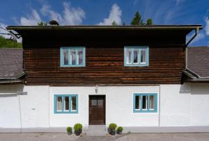 a large white house with a wooden roof at ALBA MOUNTAIN CHALETS in Gusswerk