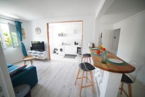 a kitchen and living room with a table and chairs at Edith, T2 design plage Gros-Raisins Sainte-Luce in Sainte-Luce